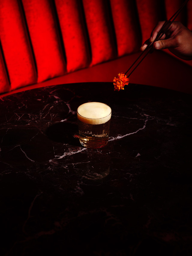 A flower falling to the surface of a drink